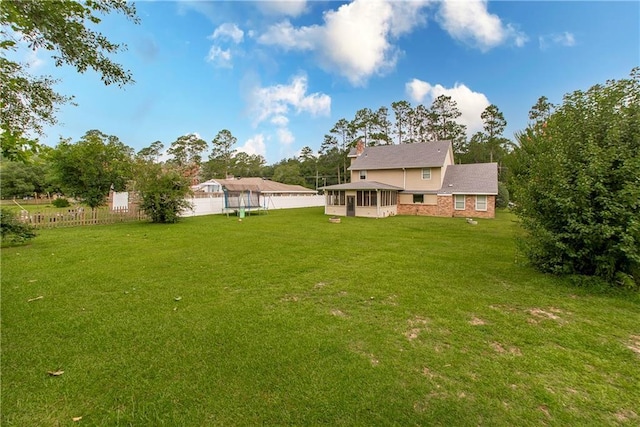 view of yard with fence and a sunroom