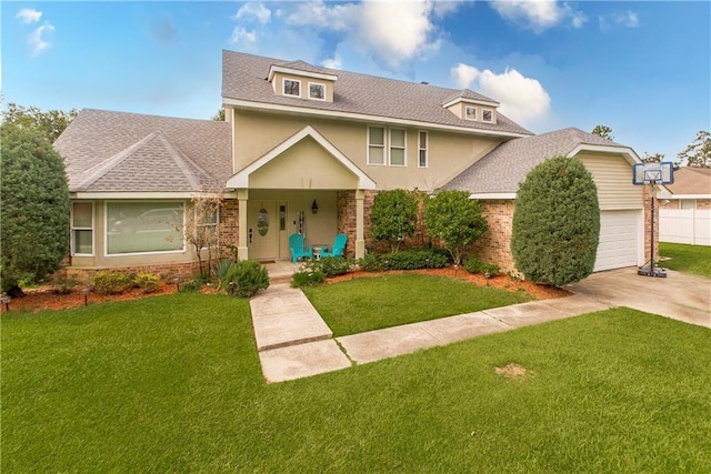 view of front of house with stucco siding, a front lawn, an attached garage, a shingled roof, and brick siding