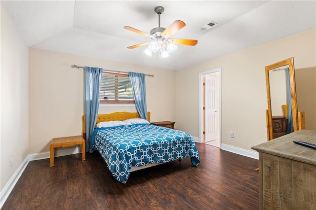 bedroom with ceiling fan, dark wood-type flooring, and vaulted ceiling