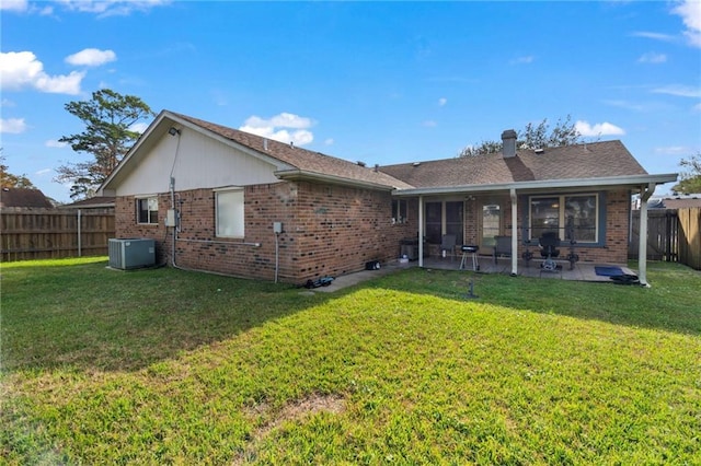 rear view of house with a yard, cooling unit, and a patio area