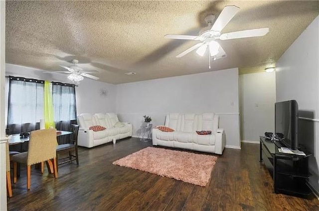 living room with ceiling fan, dark wood-type flooring, and a textured ceiling