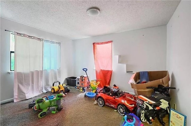 game room with a wealth of natural light and a textured ceiling