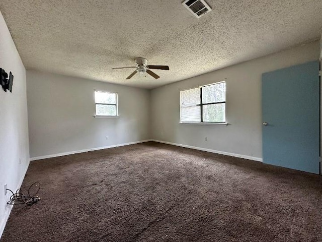 carpeted empty room featuring ceiling fan, a healthy amount of sunlight, and a textured ceiling