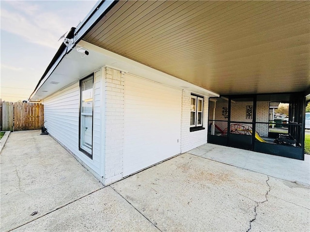 view of patio / terrace with an attached carport and fence