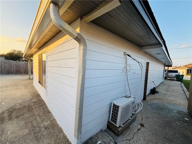 view of property exterior with ac unit and fence