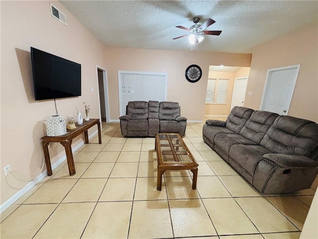 living area with visible vents, baseboards, light tile patterned flooring, a textured ceiling, and a ceiling fan