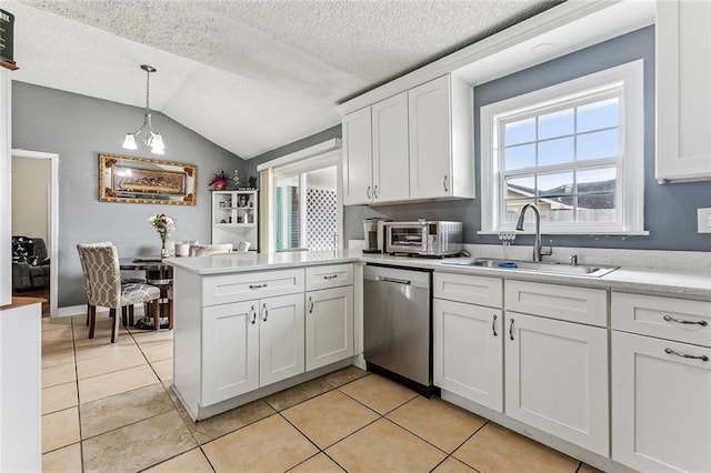 kitchen featuring white cabinetry, a peninsula, a sink, light countertops, and stainless steel dishwasher