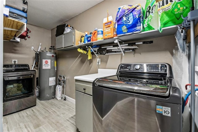 washroom with light wood-type flooring, independent washer and dryer, water heater, and laundry area