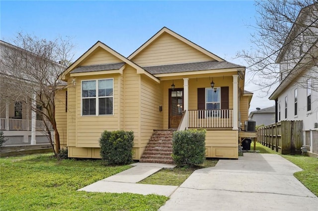 bungalow-style house featuring central AC, covered porch, and a front yard