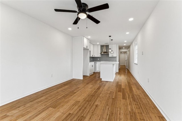 unfurnished living room with light hardwood / wood-style flooring and ceiling fan