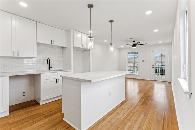 kitchen featuring ceiling fan, white cabinetry, sink, and tasteful backsplash