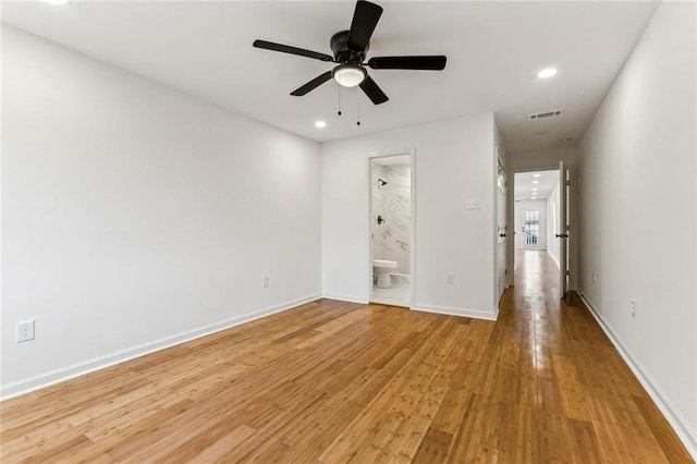 unfurnished bedroom featuring ensuite bathroom, ceiling fan, and light wood-type flooring