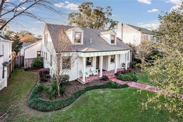 back of property with a lawn and a porch