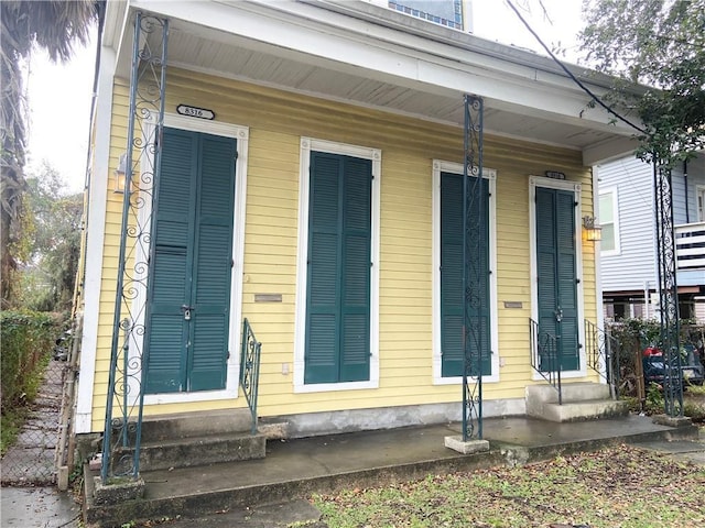 view of exterior entry featuring covered porch