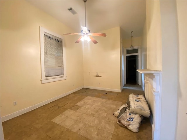 spare room featuring ceiling fan, visible vents, and baseboards