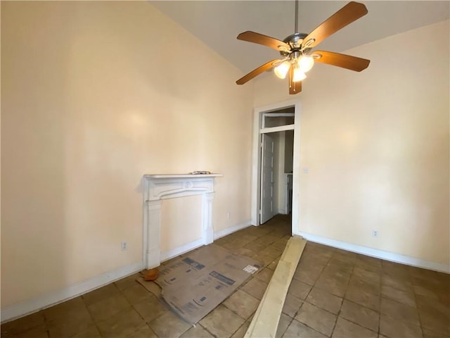 unfurnished room featuring a ceiling fan, vaulted ceiling, and baseboards