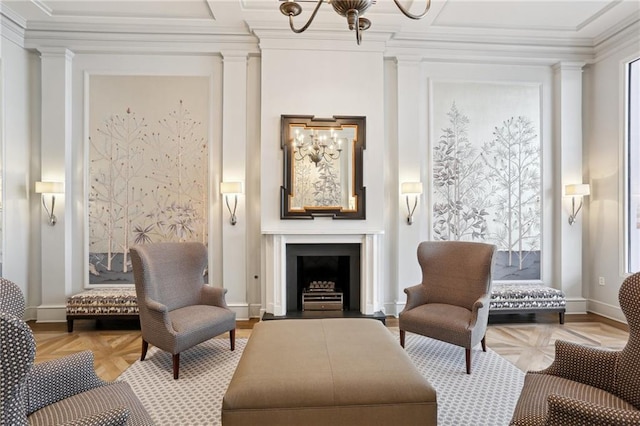 sitting room with decorative columns, crown molding, light parquet flooring, and an inviting chandelier