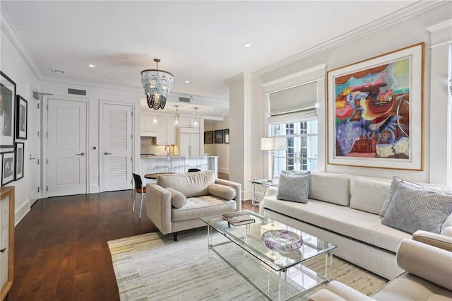 living room featuring crown molding, hardwood / wood-style floors, and a chandelier