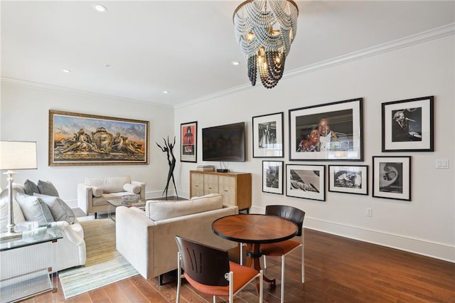 living room with hardwood / wood-style floors, ornamental molding, and an inviting chandelier