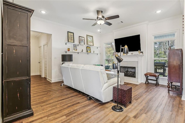 living room featuring a healthy amount of sunlight, ornamental molding, and wood finished floors