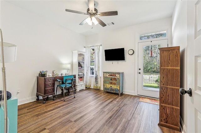 office featuring a ceiling fan, visible vents, baseboards, and wood finished floors