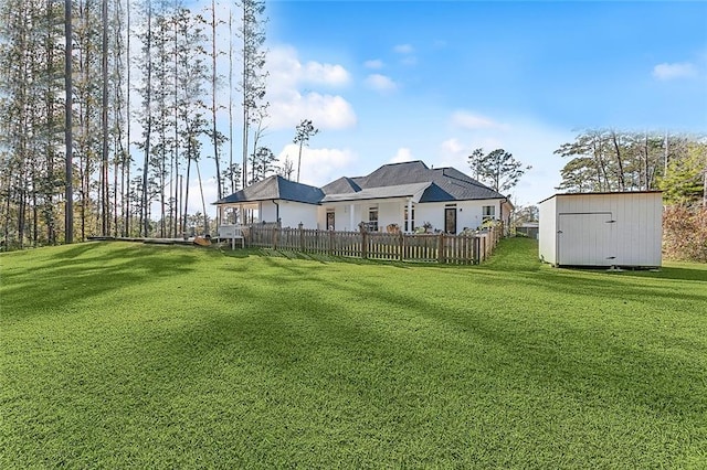 view of yard with a storage shed, an outdoor structure, and fence