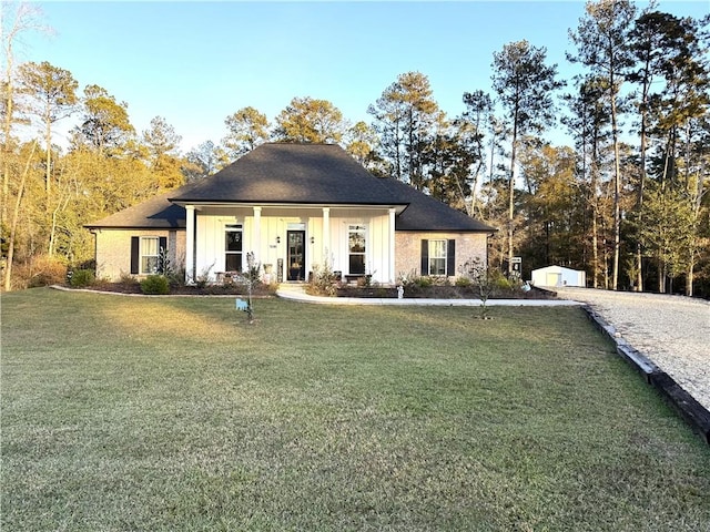 view of front of home featuring an outbuilding, board and batten siding, and a front yard