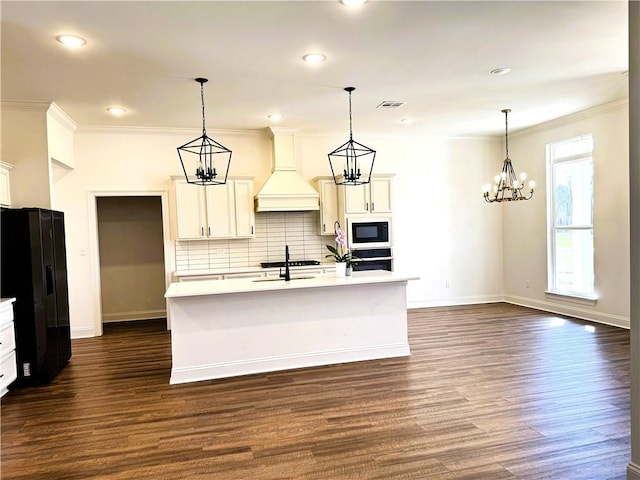 kitchen with visible vents, light countertops, custom exhaust hood, built in microwave, and black refrigerator with ice dispenser