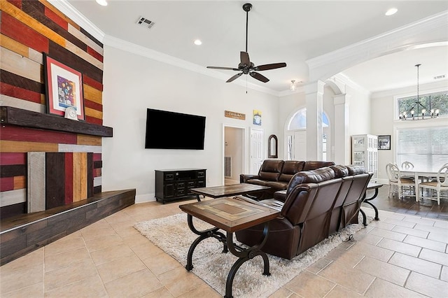 tiled living room with crown molding and ceiling fan with notable chandelier