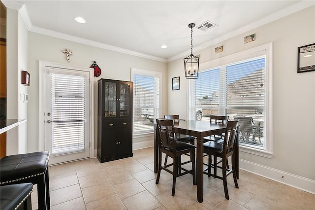 tiled dining room with ornamental molding and a chandelier