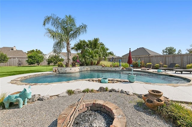 view of pool featuring pool water feature, an outdoor fire pit, a patio, and a lawn