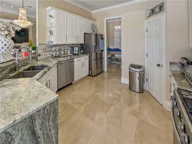 kitchen featuring light stone counters, stainless steel appliances, sink, pendant lighting, and white cabinetry