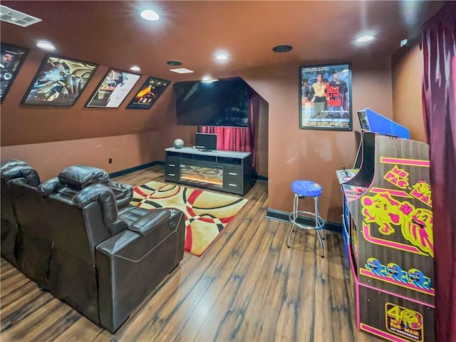 home theater with hardwood / wood-style flooring and vaulted ceiling