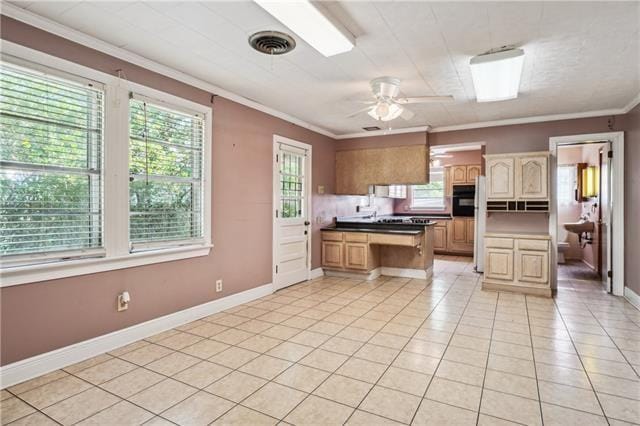 kitchen featuring light tile patterned floors, ornamental molding, a kitchen island, ceiling fan, and oven