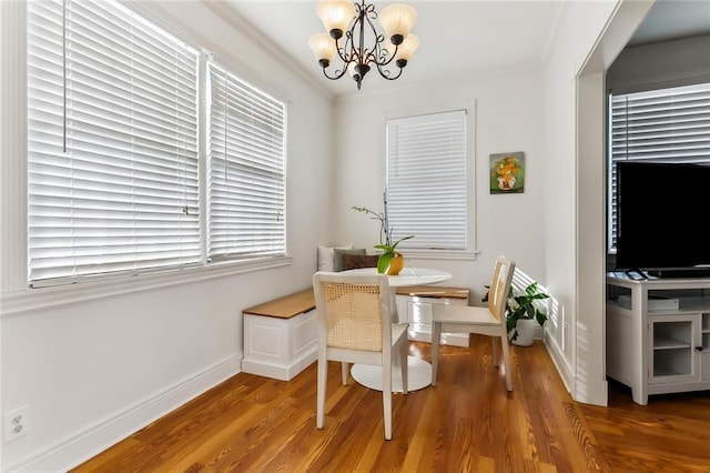 dining space featuring hardwood / wood-style flooring, a notable chandelier, and ornamental molding