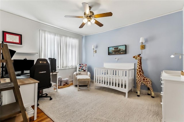 bedroom featuring a crib and ceiling fan