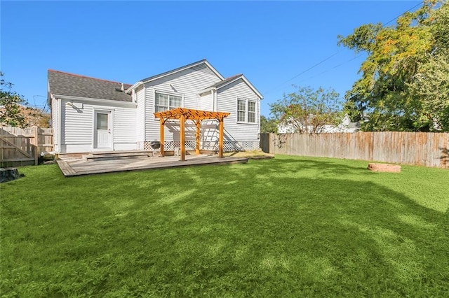 back of property with a pergola, a lawn, and a deck