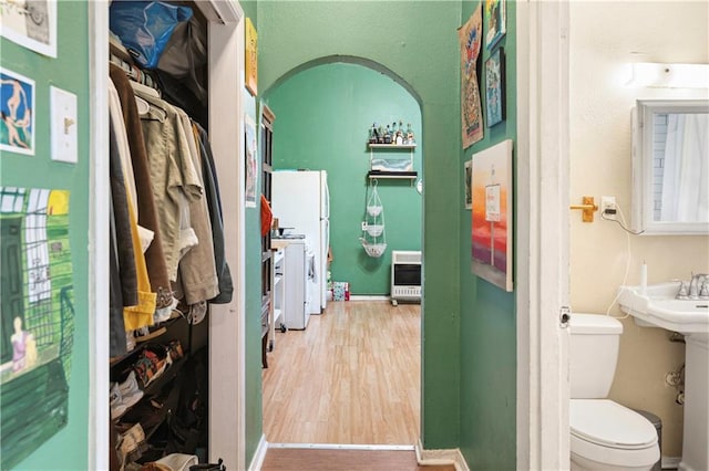 bathroom featuring hardwood / wood-style flooring, toilet, and heating unit