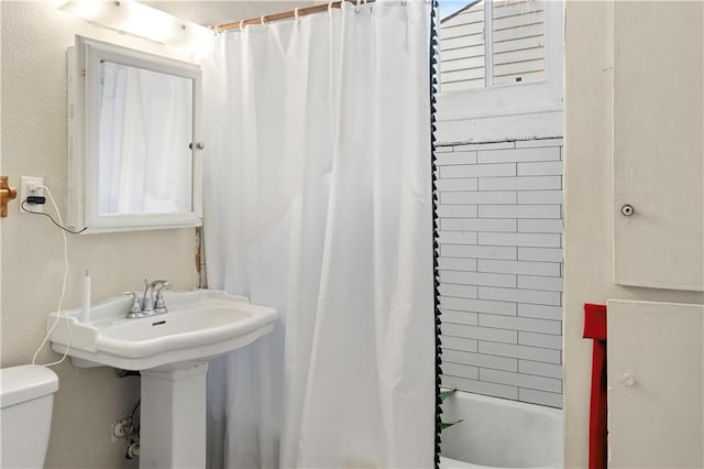 bathroom featuring toilet and shower / bathtub combination with curtain