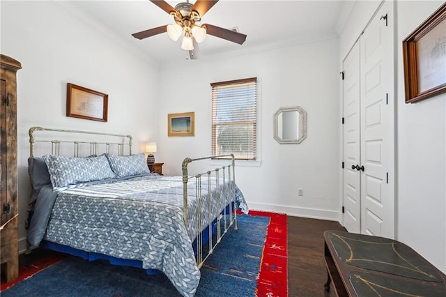 bedroom featuring dark hardwood / wood-style flooring, a closet, ceiling fan, and ornamental molding