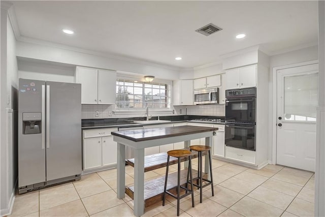 kitchen featuring white cabinetry, stainless steel appliances, and decorative backsplash