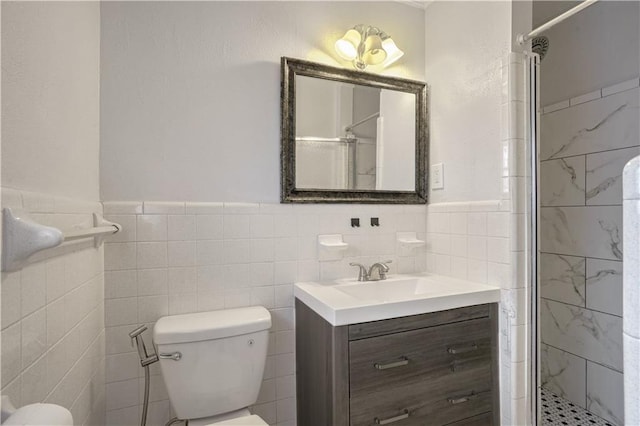 bathroom with vanity, a shower with shower door, tile walls, and toilet