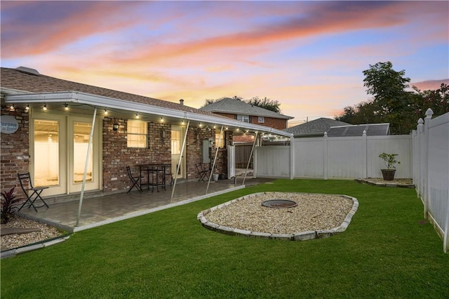 yard at dusk with a patio area