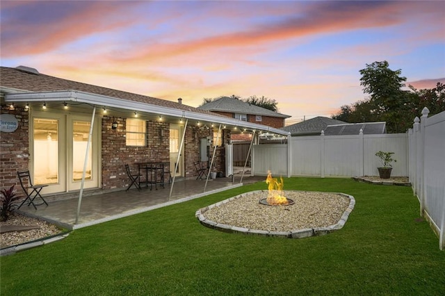 yard at dusk with a patio area and an outdoor fire pit