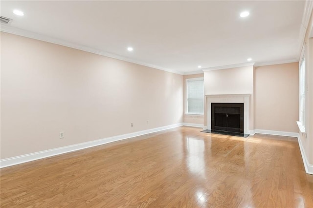 unfurnished living room featuring light wood-type flooring and ornamental molding