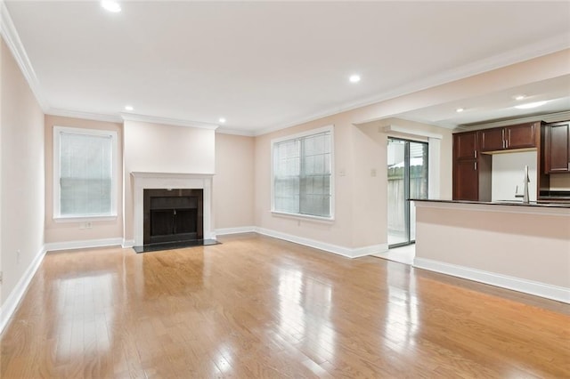 unfurnished living room with ornamental molding and light hardwood / wood-style flooring