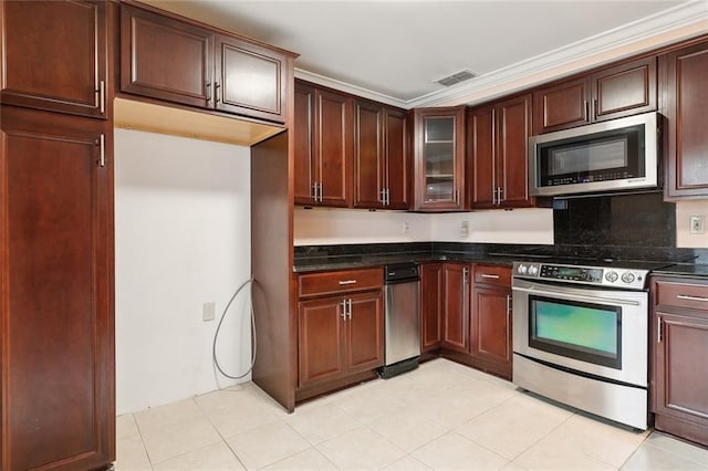 kitchen featuring decorative backsplash, appliances with stainless steel finishes, dark stone counters, and crown molding