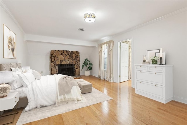 bedroom with a fireplace, light wood-type flooring, and ornamental molding