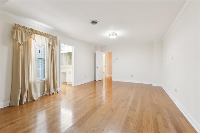 empty room with light hardwood / wood-style floors and ornamental molding