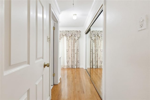 hall with light wood-type flooring and crown molding